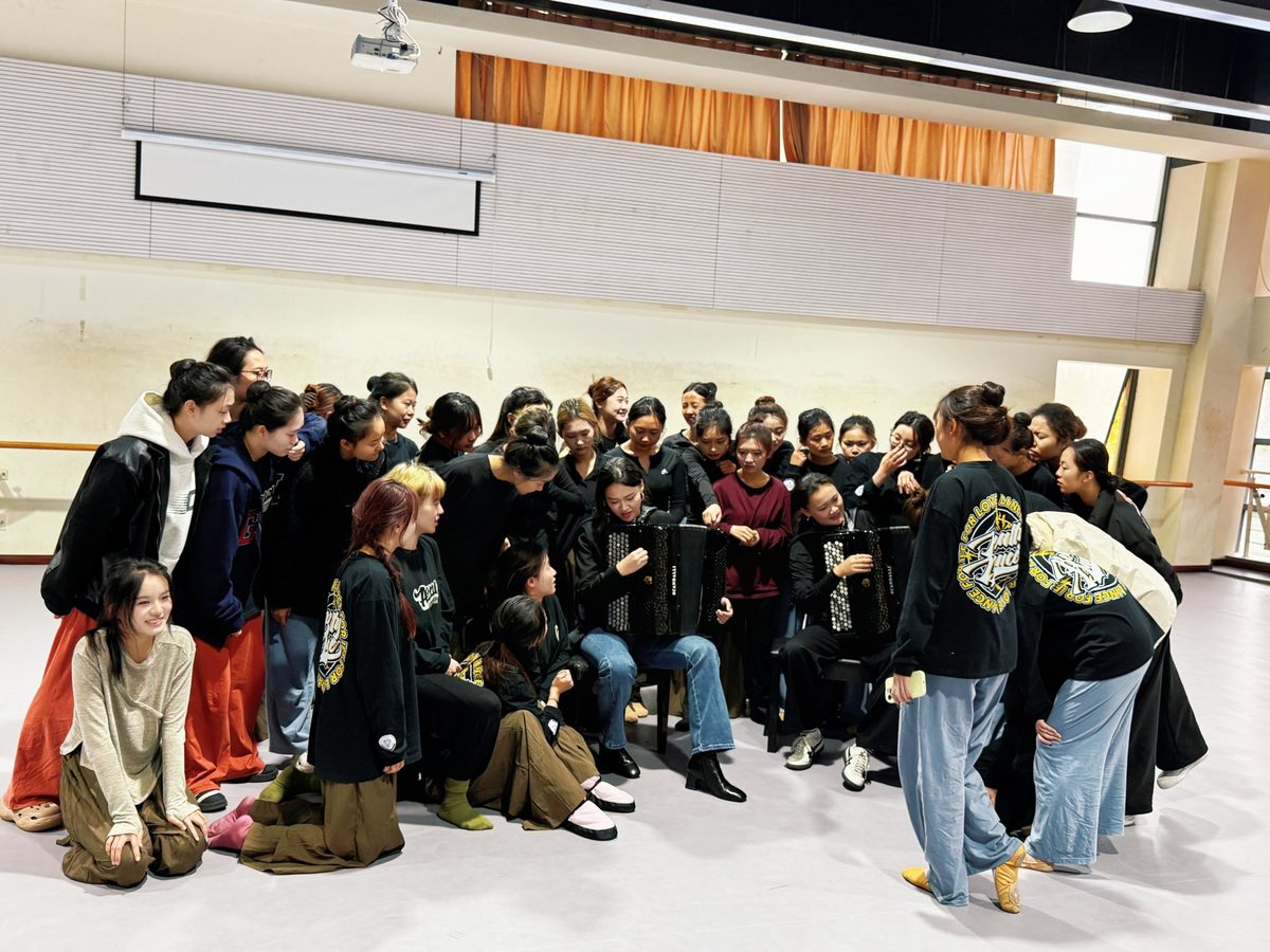 Workshop with dance students gathered around the two accordions